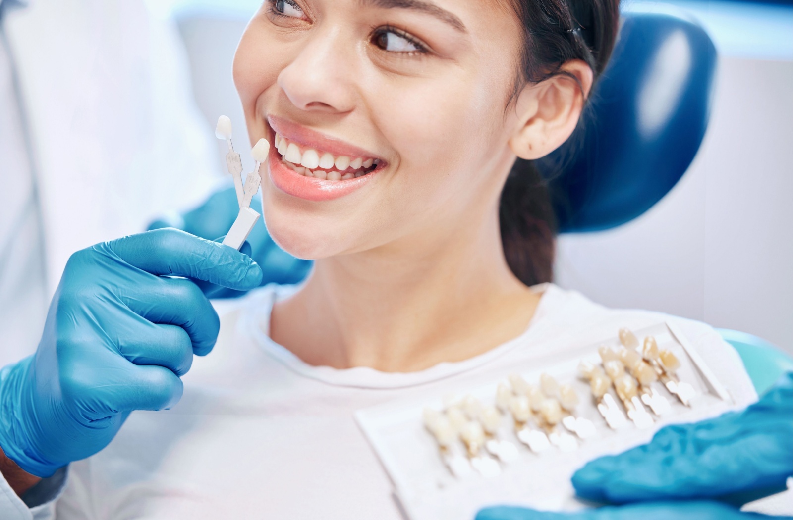 Dentist matching veneer shades to a patient's teeth for cosmetic dental treatment
