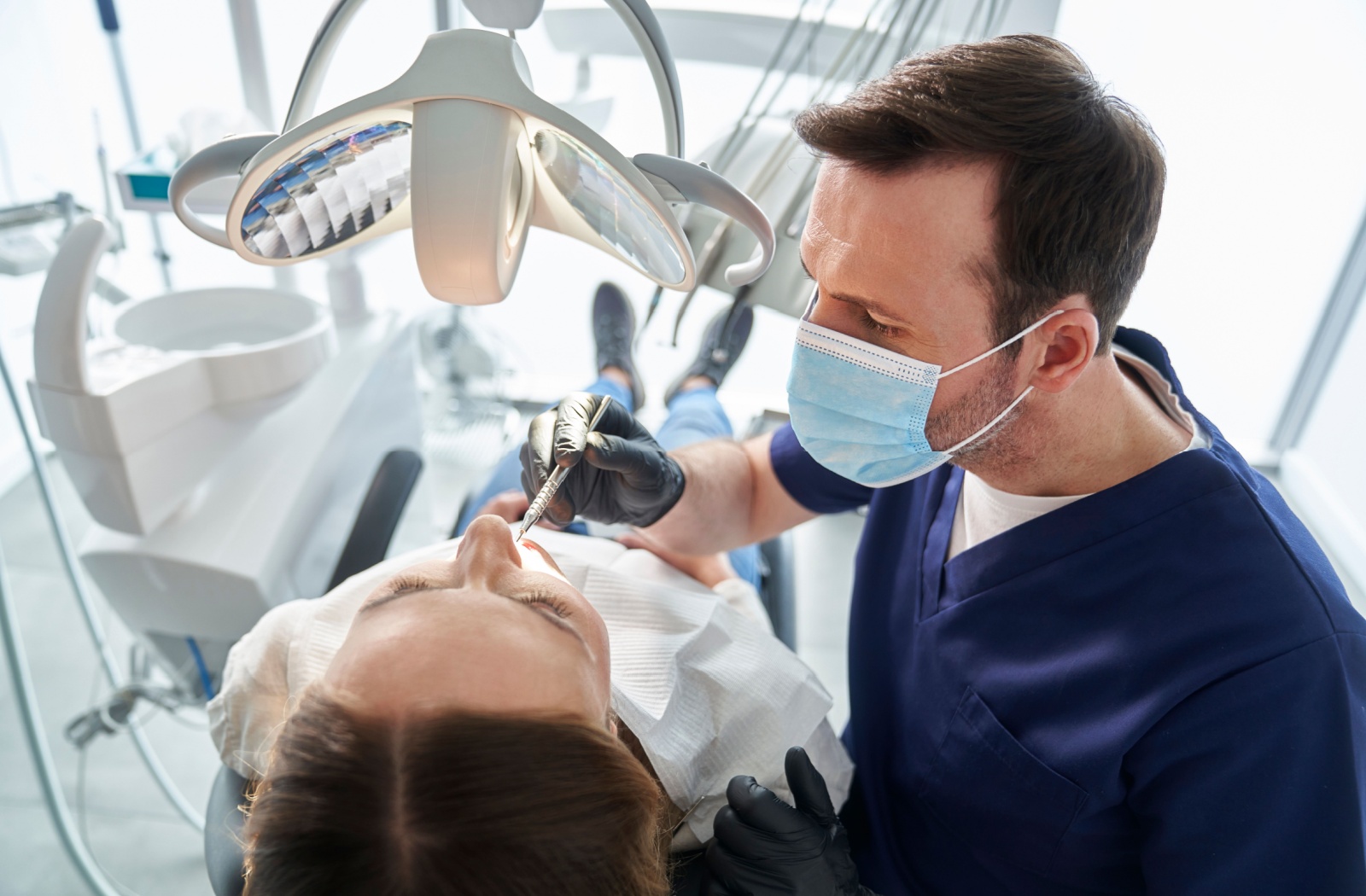 A dentist examines their patients mouth to check on their overal oral health.