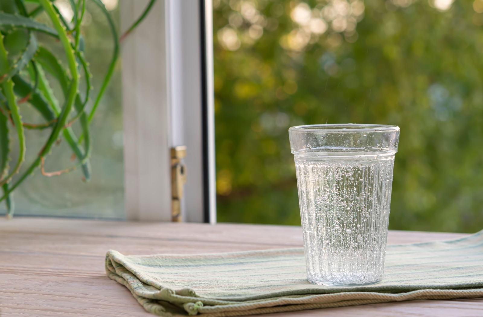 A glass of water on top of a cloth resting on a table