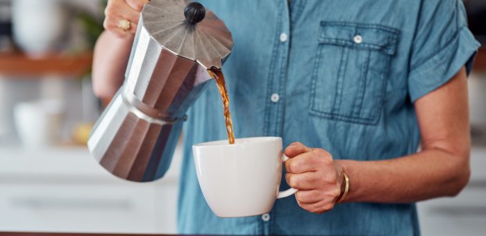 A close-up image of someone pouring a cup of coffee.