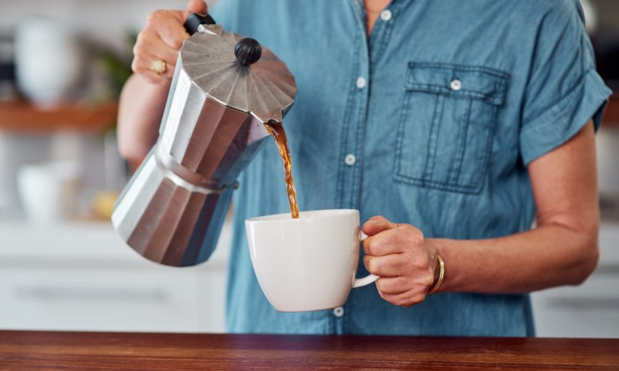 A close-up image of someone pouring a cup of coffee.